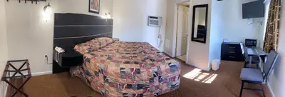 a bedroom with a bed and a desk and a chair at Penn Amish Motel in Denver