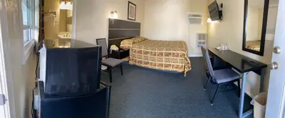 a small hotel room with a bed and a desk at Penn Amish Motel in Denver