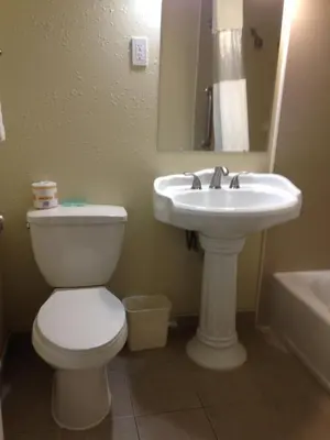 a bathroom with a toilet and a sink at Penn Amish Motel in Denver