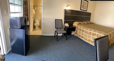 a hotel room with a bed and a flat screen tv at Penn Amish Motel in Denver
