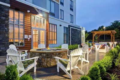 a patio with white chairs and a fire pit at Hilton Garden Inn Princeton Lawrenceville in Lawrenceville