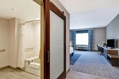 a hotel room with a door leading to a bedroom at Hilton Garden Inn Princeton Lawrenceville in Lawrenceville