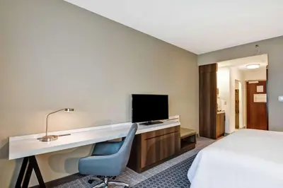 a hotel room with a desk and a bed at Hilton Garden Inn Princeton Lawrenceville in Lawrenceville