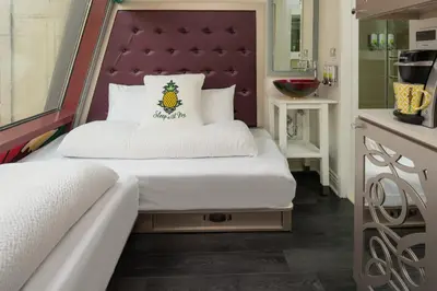 a bedroom with a bed with a purple headboard at Staypineapple, An Artful Hotel, Midtown New York in New York