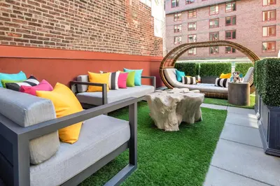 a patio with couches and a table and grass at Staypineapple, An Artful Hotel, Midtown New York in New York