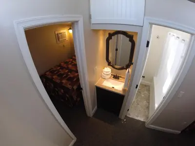 a small bathroom with a bed and a mirror at Red Caboose Motel & Restaurant in Ronks