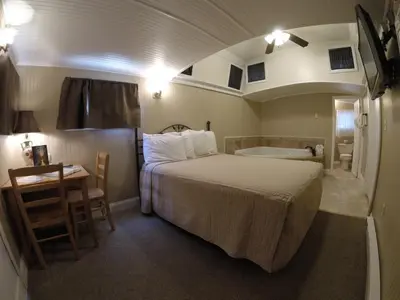 a bedroom with a bed and a bathroom with a tub at Red Caboose Motel & Restaurant in Ronks
