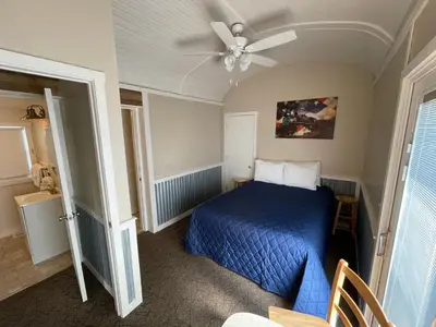 a bedroom with a blue bed and a ceiling fan at Red Caboose Motel & Restaurant in Ronks