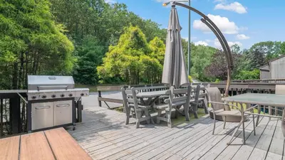 an outdoor patio with a grill and an umbrella at The Best Views From Camelback in Tannersville