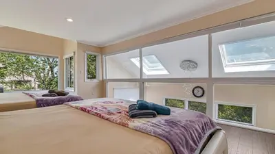 two beds in a room with large windows at The Best Views From Camelback in Tannersville