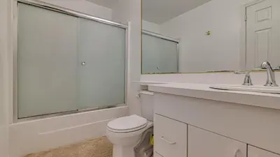 a white bathroom with a toilet and a sink at The Best Views From Camelback in Tannersville