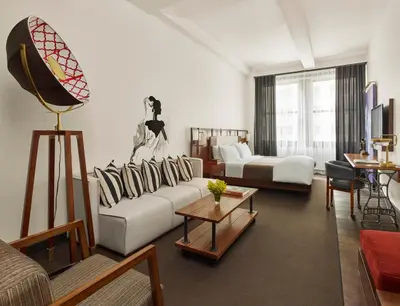 a living room with a couch and a table at Refinery Hotel - New York in New York