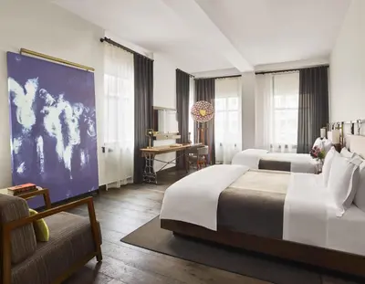 a hotel room with two beds and a couch at Refinery Hotel - New York in New York