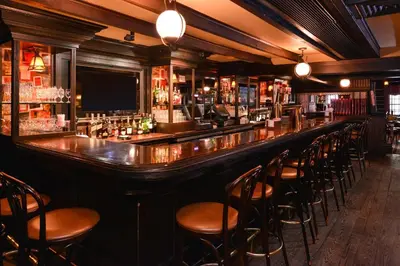 a bar with a row of stools in a room at The Madison Hotel in Morristown