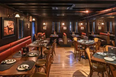 a restaurant with wooden walls and tables and chairs at The Madison Hotel in Morristown