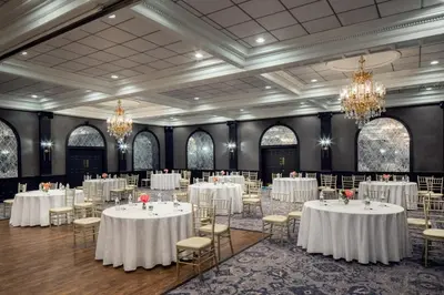 a ballroom with white tables and chairs and chandeliers at The Madison Hotel in Morristown