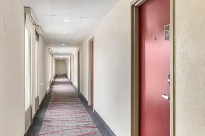a corridor of an office with a red door and a carpet at Red Roof Inn Stroudsburg in Stroudsburg