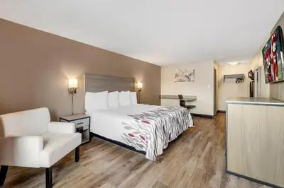 a hotel room with a bed and a chair at Red Roof Inn Stroudsburg in Stroudsburg