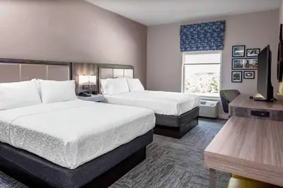 a hotel room with two beds and a television at Hampton Inn Cranbury in Cranbury