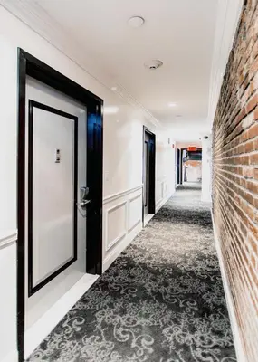 a hallway with a door and a brick wall at East Village Hotel in New York