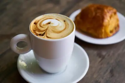 a cup of coffee and a pastry on a table at Hotel Rock Lititz in Lititz