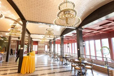 a dining hall with tables and chairs and chandeliers at The Albion Summit in Summit