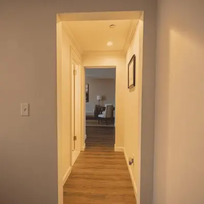 a hallway leading into a living room with wood floors at The Albion Summit in Summit