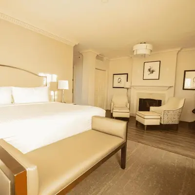 a white bedroom with a bed and a fireplace at The Albion Summit in Summit