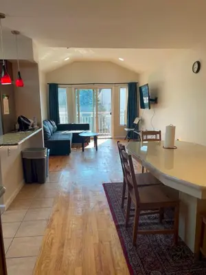 a kitchen and living room with a table and chairs at Business & Family Friendly Balcony Jacuzzi Free Park in Jersey City