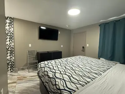 a bedroom with a bed and a flat screen tv at Beauty Rest Hotel in Edison