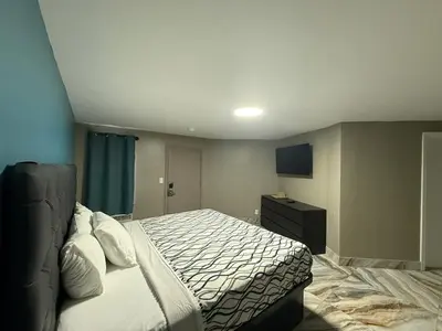 a bedroom with a bed and a dresser in it at Beauty Rest Hotel in Edison