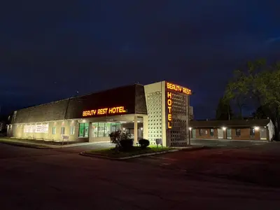 a building with a sign that reads happy best motel at Beauty Rest Hotel in Edison