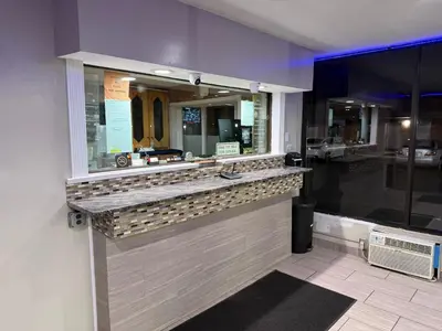 a restaurant with a counter with a window at Beauty Rest Hotel in Edison