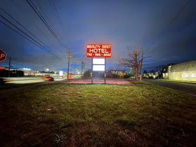 a sign for a hotel on the side of a road at Beauty Rest Hotel in Edison