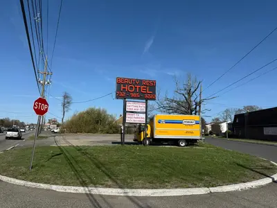a yellow truck is parked next to a sign at Beauty Rest Hotel in Edison