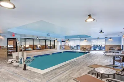 a pool in a large room with tables and chairs at TownePlace Suites by Marriott Bridgewater Branchburg in Branchburg Park