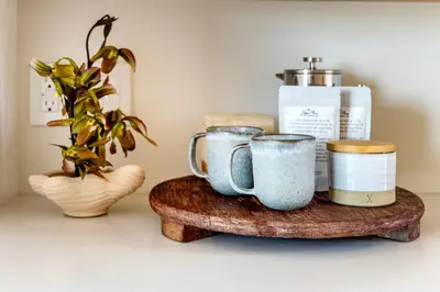 a group of mugs on a wooden tray with a plant at Collective Retreats Governors Island in New York