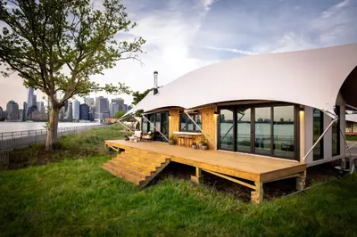 a dome house with a deck on the water at Collective Retreats Governors Island in New York