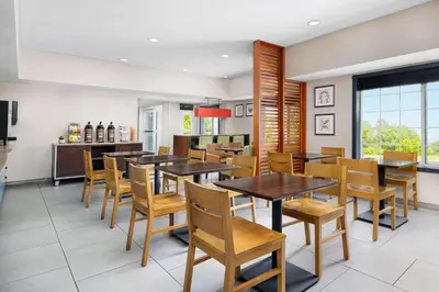 a dining room with wooden tables and chairs at Country Inn & Suites by Radisson, Big Flats (Elmira), NY in Horseheads