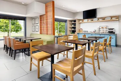 a dining room with wooden tables and chairs at Country Inn & Suites by Radisson, Big Flats (Elmira), NY in Horseheads