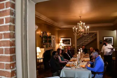 a group of people sitting at a table in a restaurant at The Sayre Mansion in Bethlehem