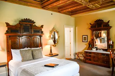 a bedroom with a large bed with a dresser and a mirror at The Sayre Mansion in Bethlehem