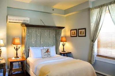 a bedroom with a bed and two lamps and a window at The Sayre Mansion in Bethlehem