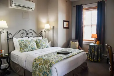 a bedroom with a large bed with a white bedspread at The Sayre Mansion in Bethlehem