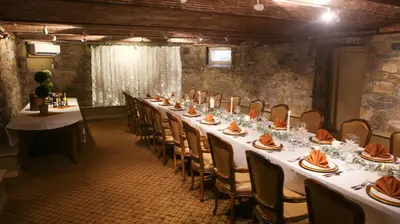 a long table in a room with white tables and chairs at The Sayre Mansion in Bethlehem