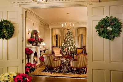 a living room with a christmas tree and chairs at The Sayre Mansion in Bethlehem