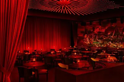 a restaurant with red curtains and tables and chairs at The Times Square EDITION New York in New York