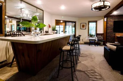 a bar with stools in a living room at Big House On The Hill in East Stroudsburg