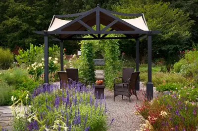 a gazebo in a garden with purple flowers at Settlers Inn in Hawley