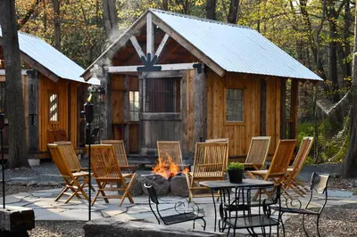 a group of chairs and a table and a cabin at Settlers Inn in Hawley